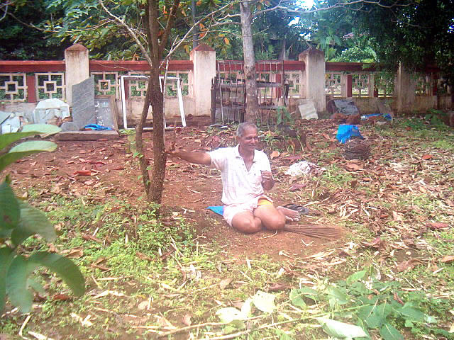 Guruji Shri Suresh J Pai sipping tea during a break while sweeping the garden area
